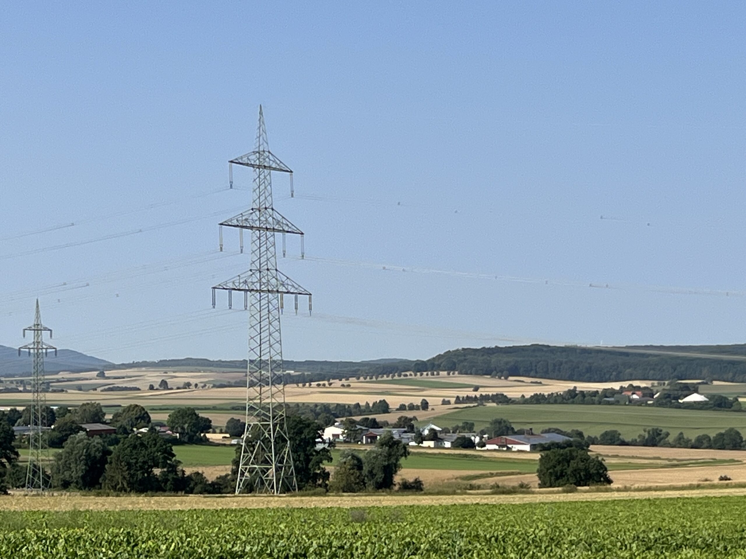 Stromleitungen und Hochspannungsmasten in ländlicher Umgebung